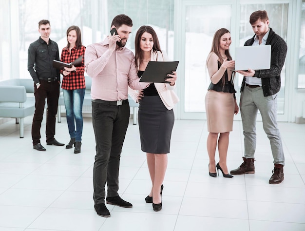 Equipo de negocios discutiendo documentos en el vestíbulo de la oficina