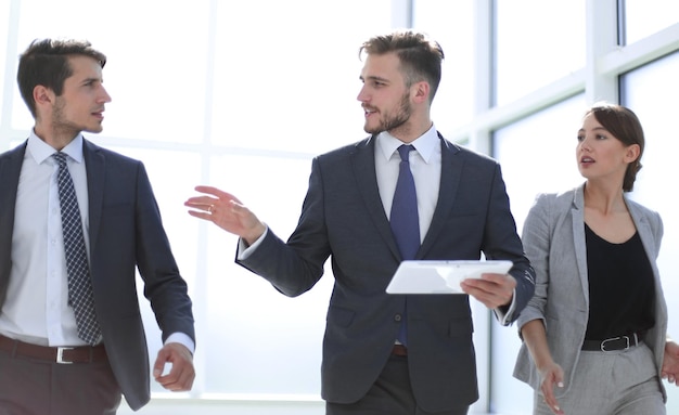 Equipo de negocios discutiendo nueva estrategia juntos, personas y tecnología.