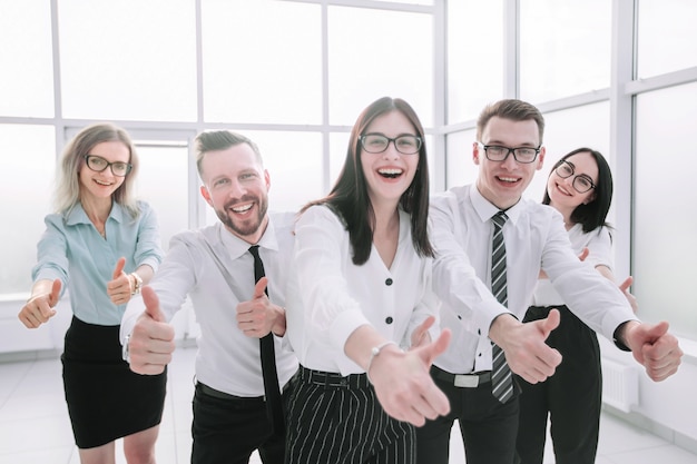 Equipo de negocios divertido mostrando sus pulgares para arriba. concepto de éxito