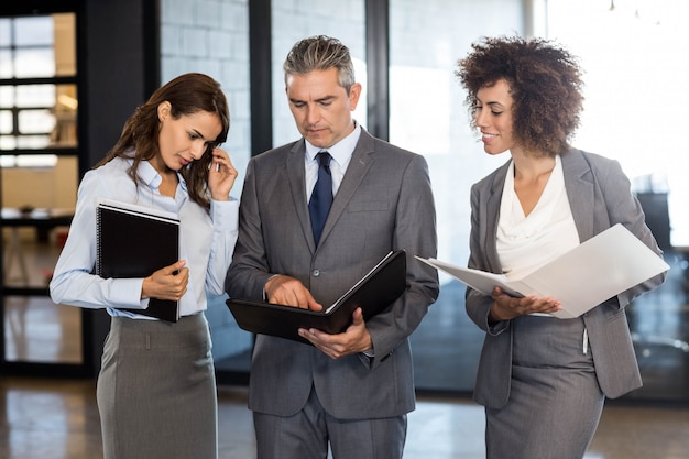 Equipo de negocios con documento y organizador en oficina.