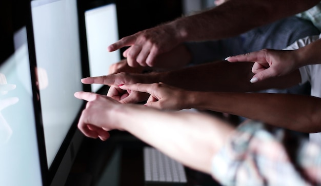 El equipo de negocios está apuntando a los monitores de sus computadoras.