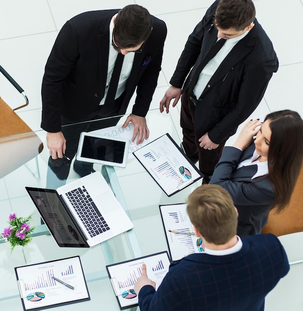 Equipo de negocios exitoso discutiendo gráficos de marketing antes de la reunión