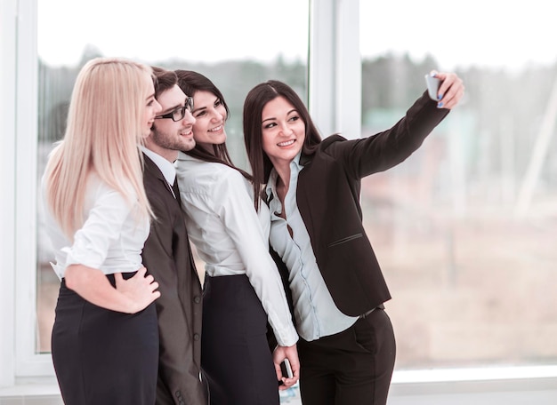 Foto el equipo de negocios exitoso está haciendo un selfie en el vestíbulo de la oficina moderna