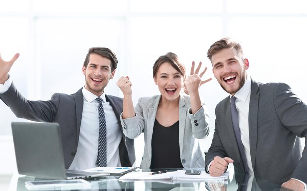 Foto equipo de negocios exitoso sentado en el escritorio