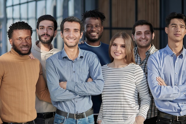 Equipo de negocios exitoso sonriendo mientras está de pie en la oficina