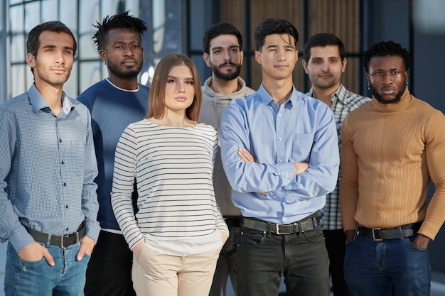 Foto equipo de negocios exitoso sonriendo mientras está de pie en la oficina