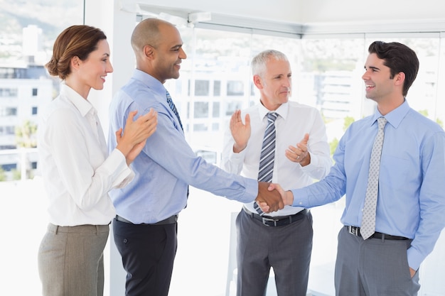 Equipo de negocios felicitando a su colega