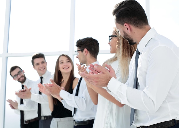 El equipo de negocios feliz aplaude mientras está de pie en la foto de la oficina con espacio para copiar