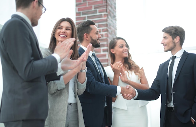 El equipo de negocios feliz aplaude a los nuevos socios comerciales