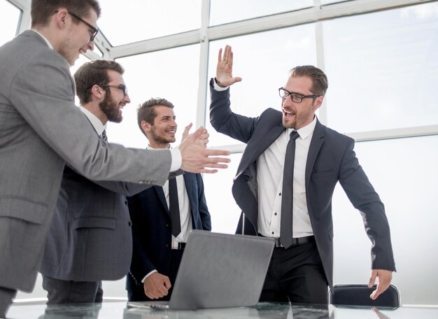 Equipo de negocios feliz dándose unos a otros cinco concepto de éxito