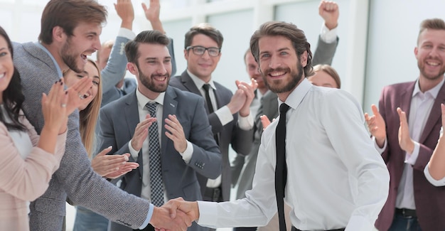 Equipo de negocios feliz felicitando a los jóvenes socios comerciales