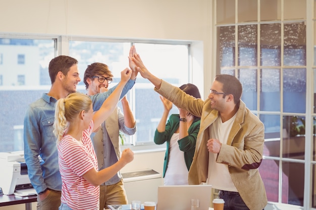 Equipo de negocios feliz haciendo chequeos de manos