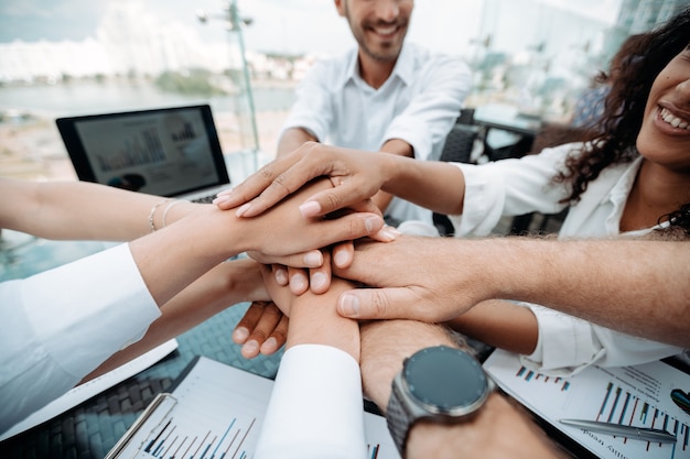 Equipo de negocios feliz haciendo una torre de sus manos