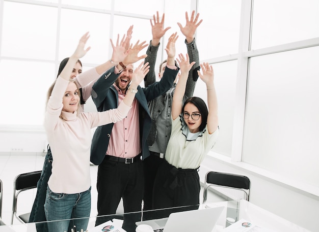 Equipo de negocios feliz con las manos en alto mostrando su desempeño exitoso. el concepto de trabajo en equipo