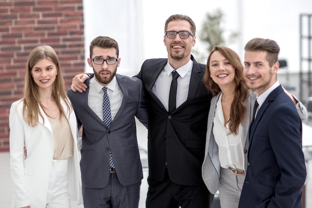 Equipo de negocios feliz de pie juntos el concepto de trabajo en equipo