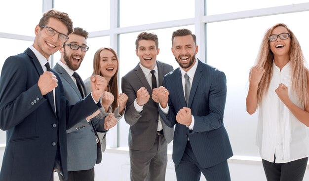 Equipo de negocios feliz de pie en la oficina concepto de éxito