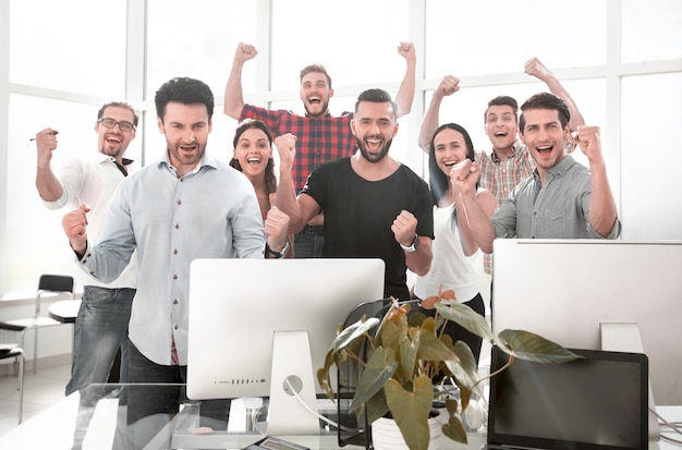 Equipo de negocios feliz de pie en la oficina moderna