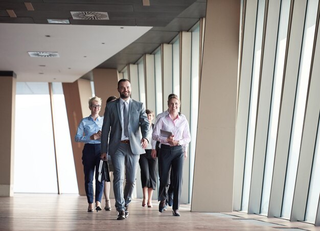 equipo de negocios, grupo de empresarios caminando en el moderno y luminoso interior de la oficina