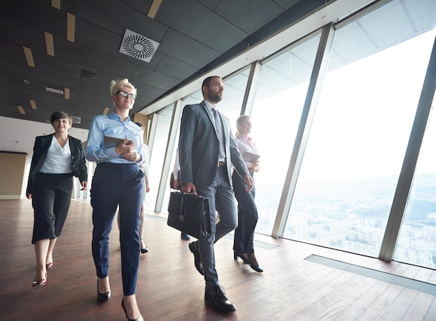 equipo de negocios, grupo de empresarios caminando en el moderno y luminoso interior de la oficina