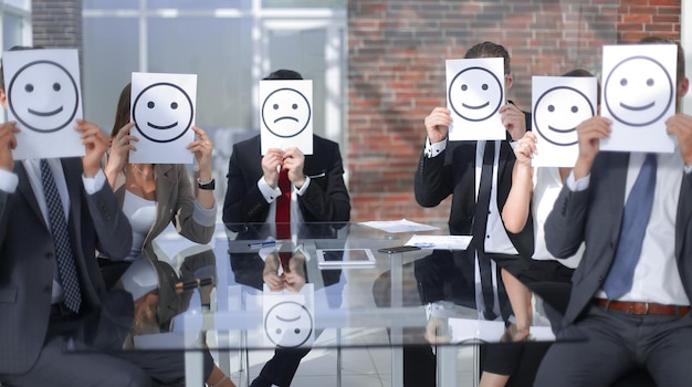 Equipo de negocios con iconos sonrientes sentados en el concepto Deskbusiness