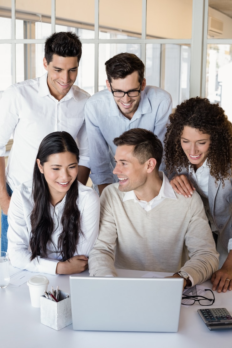 Foto equipo de negocios informal que tiene una reunión usando la computadora portátil
