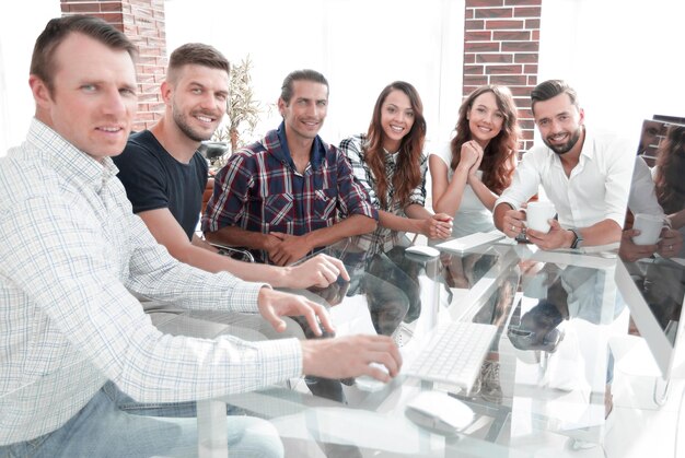 Equipo de negocios joven sentado en el escritorio