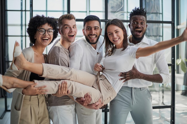 Equipo de negocios lanzando a su colega en la oficina