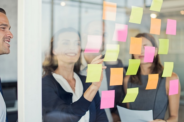 Equipo de negocios mirando notas adhesivas