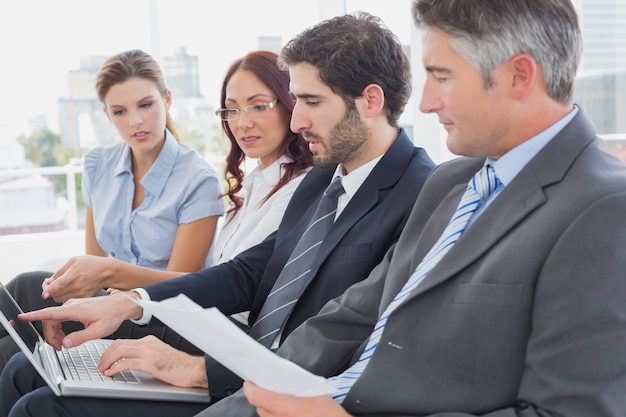 Equipo de negocios mirando portátil