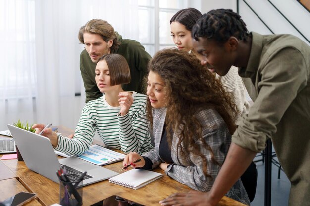 Equipo de negocios multicultural discutiendo las tareas actuales para un nuevo proyecto