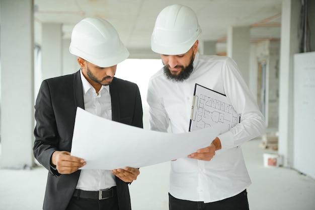Equipo de negocios multiétnico Concepto de construcción Ingenieros indios y árabes inspeccionan la construcción
