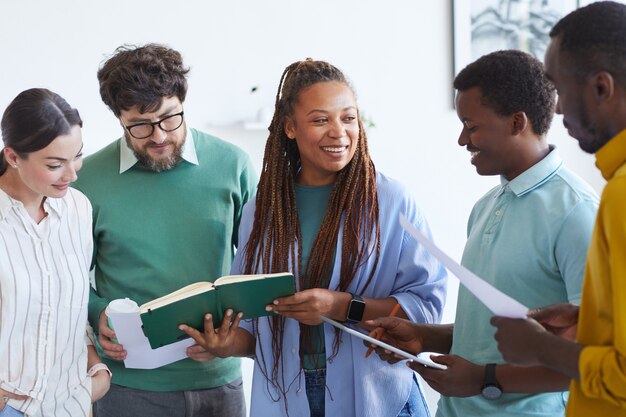 Equipo de negocios multiétnico escuchando sonriente mujer afroamericana durante la reunión en la oficina