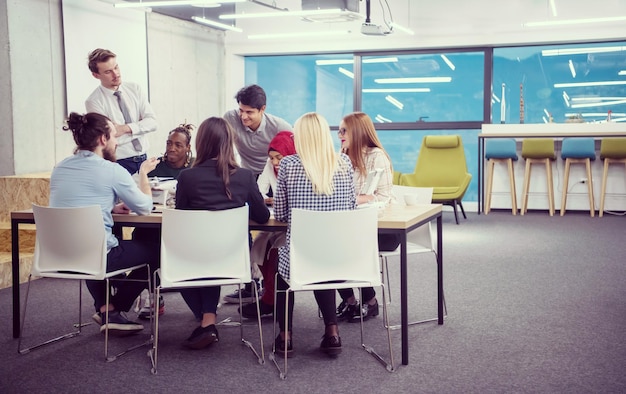 equipo de negocios multiétnico de inicio discutiendo un nuevo plan de negocios, trabajando en una computadora portátil y una tableta mientras aprende sobre la tecnología de drones para el avance de nuevos negocios