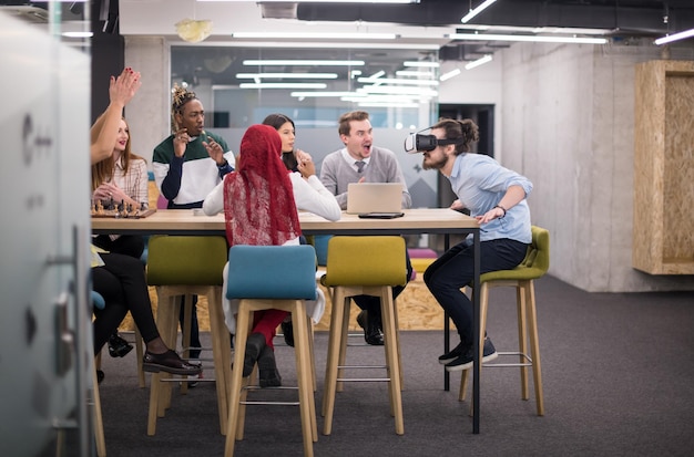 Equipo de negocios multiétnico que usa auriculares de realidad virtual en la reunión de la oficina Reunión de desarrolladores con simulador de realidad virtual alrededor de la mesa en la oficina creativa.