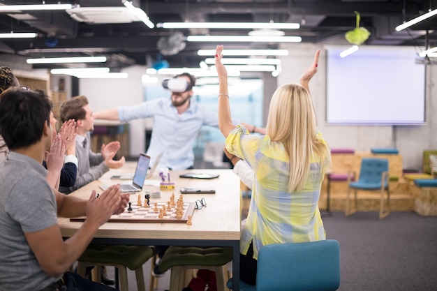 Equipo de negocios multiétnico que usa auriculares de realidad virtual en la reunión de la oficina Reunión de desarrolladores con simulador de realidad virtual alrededor de la mesa en la oficina creativa.