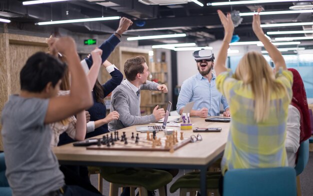 Equipo de negocios multiétnico que usa auriculares de realidad virtual en la reunión de la oficina Reunión de desarrolladores con simulador de realidad virtual alrededor de la mesa en la oficina creativa.