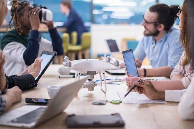 Equipo de negocios multiétnico que usa auriculares de realidad virtual en la reunión de la oficina Reunión de desarrolladores con simulador de realidad virtual alrededor de la mesa en la oficina creativa.