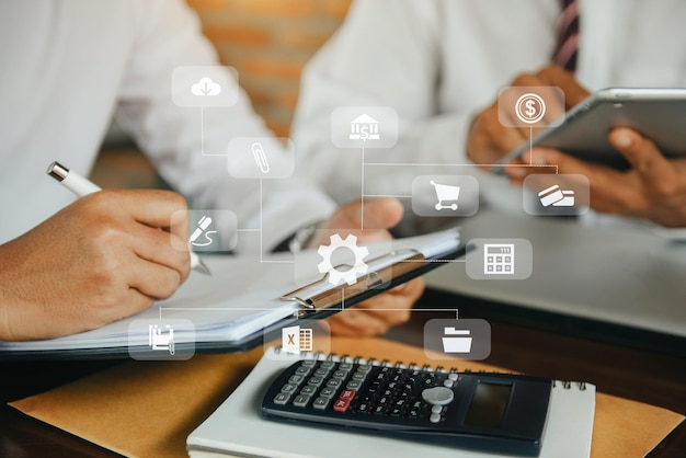 Equipo de negocios o contador que trabaja en una computadora portátil con un diagrama gráfico de documentos comerciales y una calculadora en la mesa de la oficina