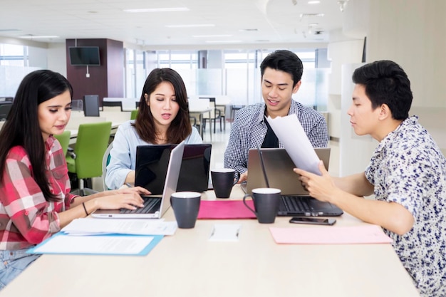 Un equipo de negocios ocupado trabaja con computadoras portátiles en la oficina