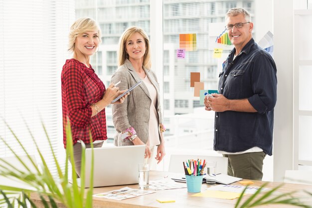 Equipo de negocios de pie mirando a la cámara