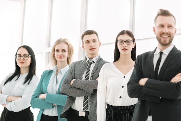 Equipo de negocios profesional de pie en una fila en una oficina luminosa