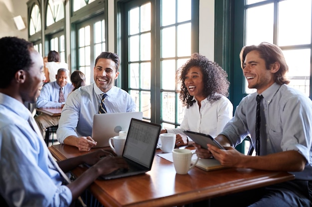 Equipo de negocios que tiene una reunión informal alrededor de una mesa en la cafetería