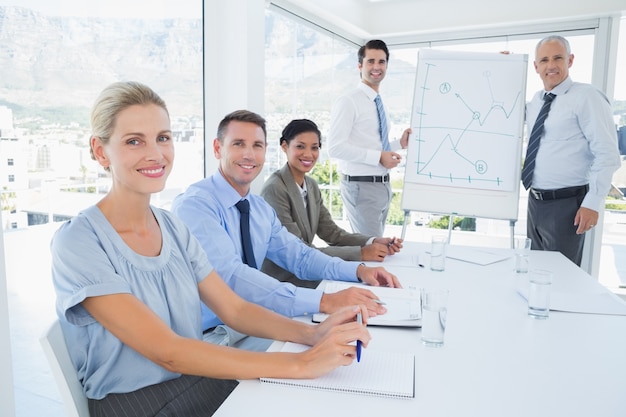 Equipo de negocios durante la reunión sonriendo a la cámara