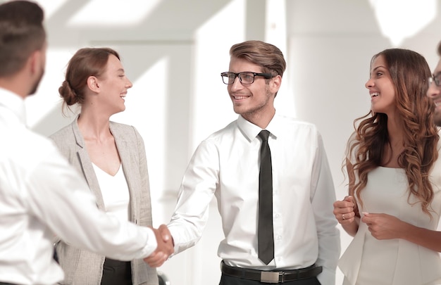 Equipo de negocios sonriente y apretón de manos de socios comerciales