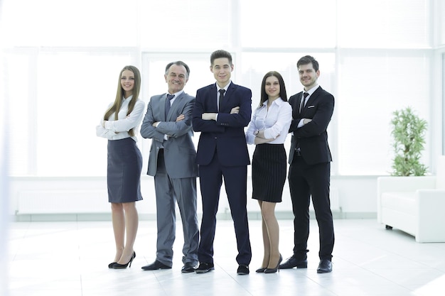 Equipo de negocios sonriente de crecimiento completo en el fondo de la oficina