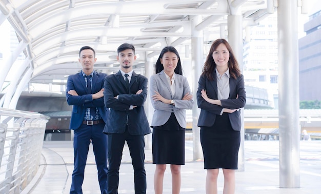 Equipo de negocios sonriente feliz de pie en el exterior