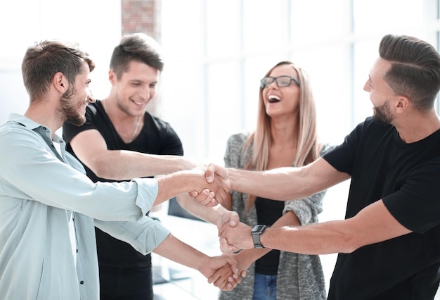 Equipo de negocios sonriente feliz de pie en una fila en la oficina