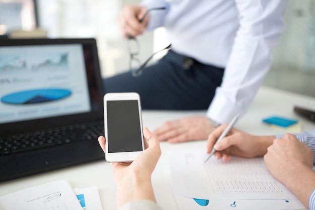 Foto equipo de negocios con teléfono inteligente trabajando en la oficina