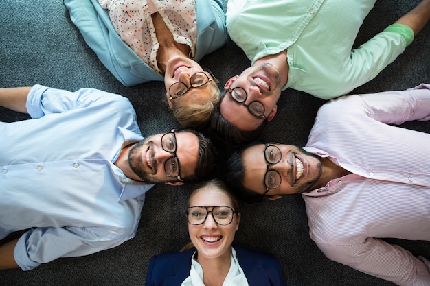 Equipo de negocios tirado en el piso con la cabeza juntos