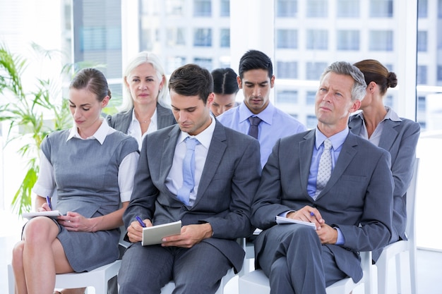 Equipo de negocios tomando notas durante la conferencia